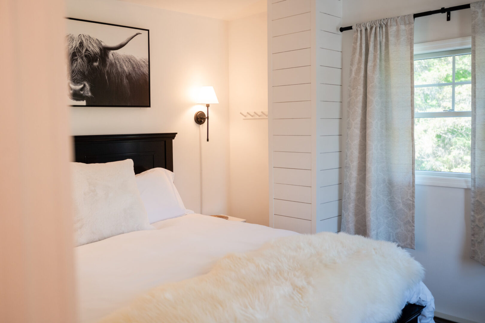A bedroom with white walls and black headboard.